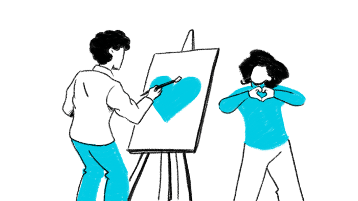 Man painting a heart on an artist's board and a girl forming a heart shape with her hands